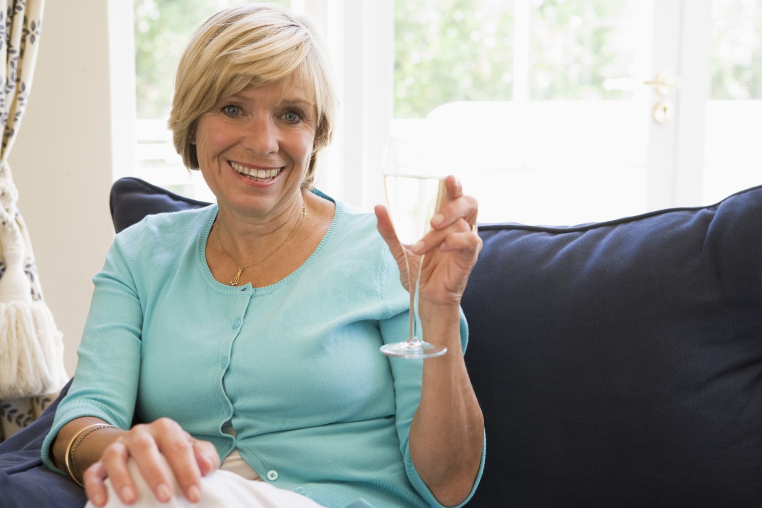 woman-sitting-in-living-room-with-drink-smiling_SY5ZDbuASj-1536x1024.jpg